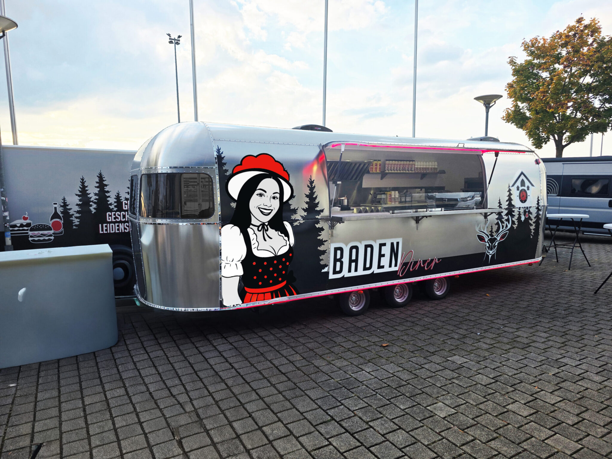 Der silberne Foodtruck des Baden Diners auf einem gepflasterten Platz